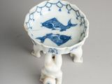 a small blue and white bowl with a fish design on it