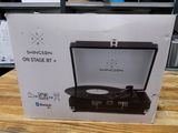 La boîte d'un tourne-disque est posée sur une table dans un magasin.