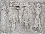 relief représentant un crucifix sur un mur de pierre, avec un homme sur la croix
