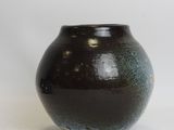 a black and blue vase sitting on a white surface