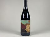 a bottle of wine sitting on top of a white table