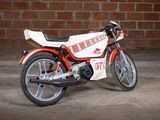 a red and white motorcycle parked in front of a brick wall