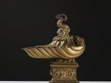 une sculpture antique en bronze représentant un coquillage surmonté d'un oiseau