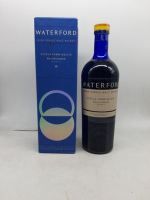 La bouteille de Waterford se trouve à côté de la boîte, sur la table.