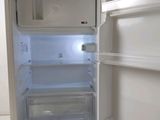 an empty refrigerator with its door open in the kitchen