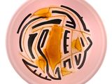une assiette rose sur laquelle se trouve un morceau de nourriture