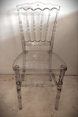 une chaise transparente posée dans un coin