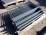 a metal grate laying on the ground next to a pallet