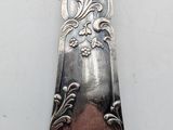 a silver spoon with a design on it sitting on a table