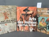trois livres posés sur une table, dont l'un comporte le dessin d'un homme coiffé d'un chapeau et l'autre celui d'une femme