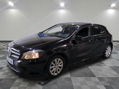une photo d'une mercedes noire de classe b garée sur un sol en damier