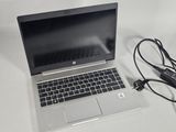 a laptop computer sitting on a table with a charger