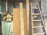 une photo d'un garage avec une échelle et un tas de bois