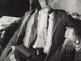 black and white photograph of a man in a suit sitting in a chair