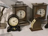 many different types of clocks displayed on a table