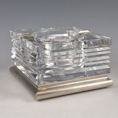 a silver and clear glass ashtray on a metal stand