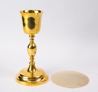 une coupe en or posée à côté d'un miroir sur une table
