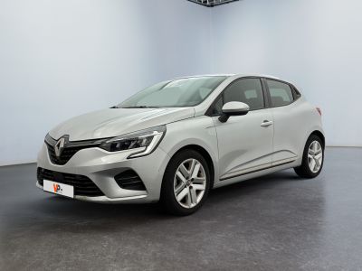 Une voiture blanche est garée dans une pièce au sol noir.
