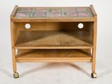 a small wooden table with a tile top on wheels