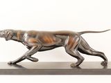 bronze statue of a dog running on a base on a white background