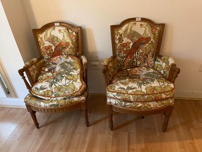 pair of chairs with floral upholstered upholstered cushions in a living room