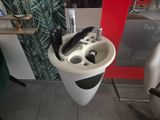un lavabo blanc dans lequel se trouve un téléphone, dans une salle de bains