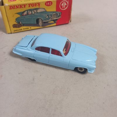 a blue toy car sitting next to a box of dinky toys