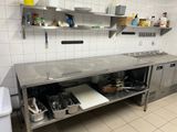 une cuisine équipée de plans de travail et d'étagères en acier inoxydable