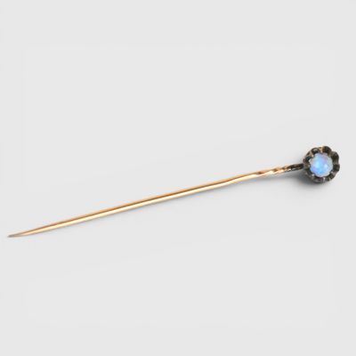 a gold and oplite stick pin with a flower design