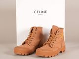 une paire de bottes marron posée sur une boîte blanche