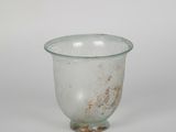 un petit verre posé sur une table blanche
