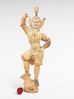 statue d'un homme tenant un oiseau sur la main, avec une balle rouge au premier plan