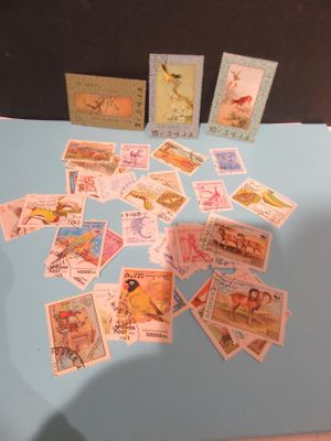 de nombreux timbres posés sur une table recouverte d'une nappe bleue