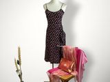 un mannequin assis sur une chaise à côté d'une robe posée sur un support pour mannequin