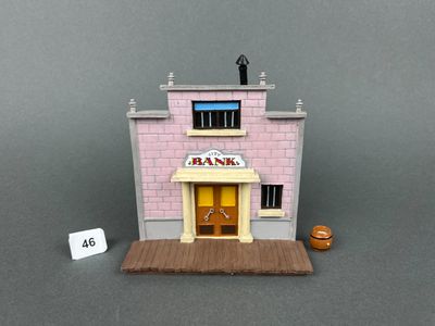 un petit bâtiment rose avec une enseigne sur la façade