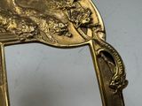 a gold mirror with a picture of a lion on it