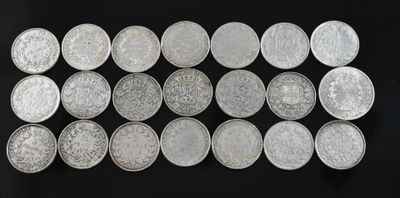a bunch of silver coins sitting on top of a black surface
