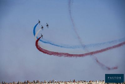 quatre avions volant dans le ciel, d'où s'échappait de la fumée rouge, blanche et bleue