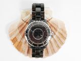 a picture of a watch sitting on a seashell