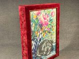 a red book with a picture of a cat and flowers on it