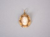 an image of a gold broochle with a shell in the center