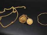 deux colliers en or et un bracelet posés sur un fond noir