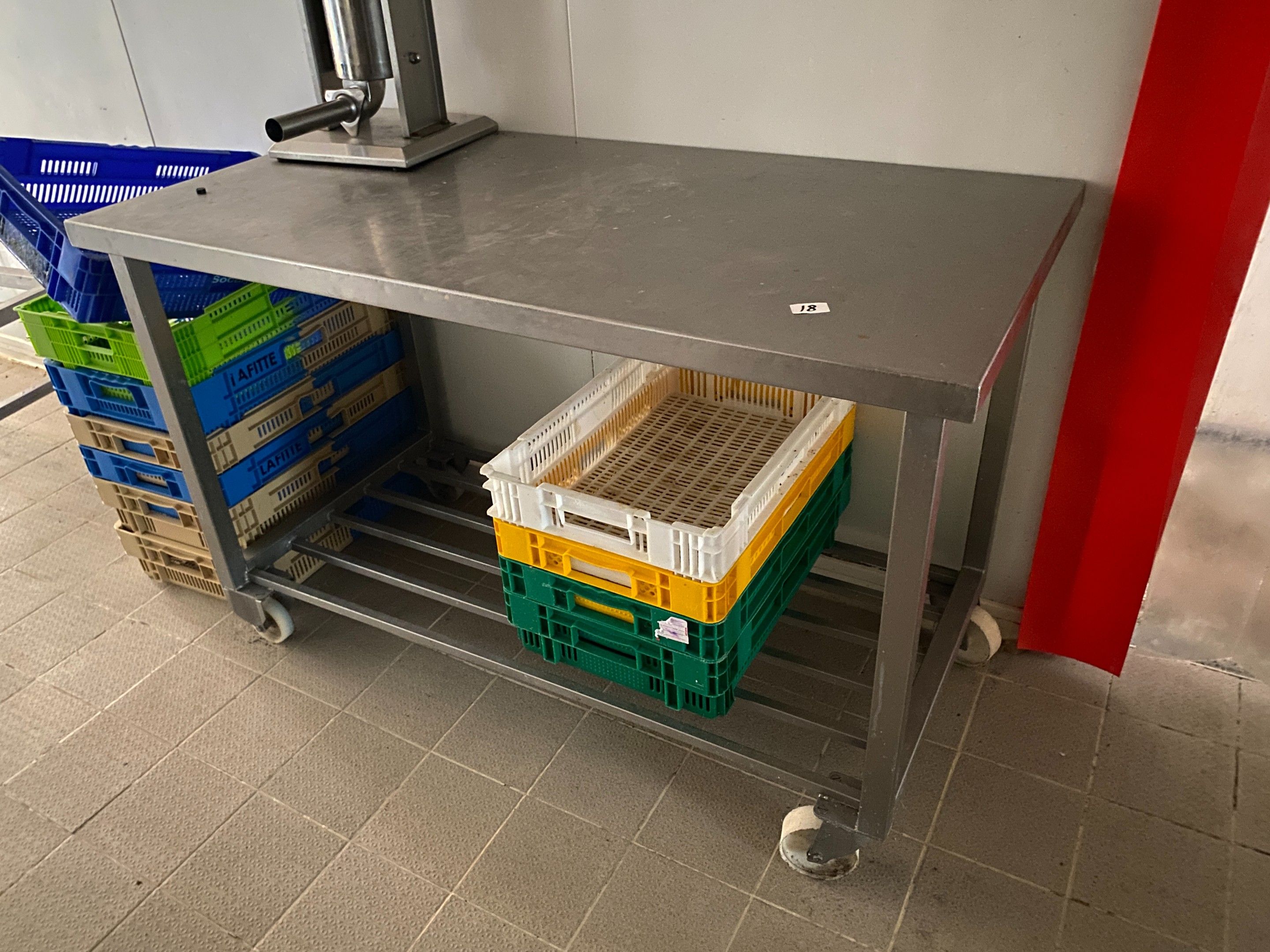 Une table en inox à claies médianes, sur roulettes Dimension…