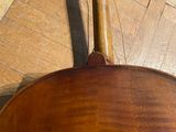 a violin that is sitting on a hard wood floor
