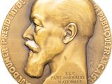 an image of a close up of a gold medal with a man ' s face