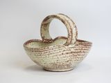 a white and brown bowl with a handle on a white background