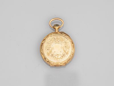 a close up of a gold pocket watch on a white surface