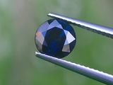 un gros plan d'un diamant bleu tenu par une pince