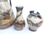 three vases sitting next to each other on a white surface