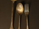 three spoons and a fork sitting on a table